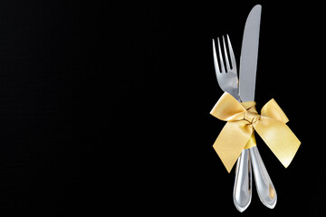 fork and knife with golden ribbon