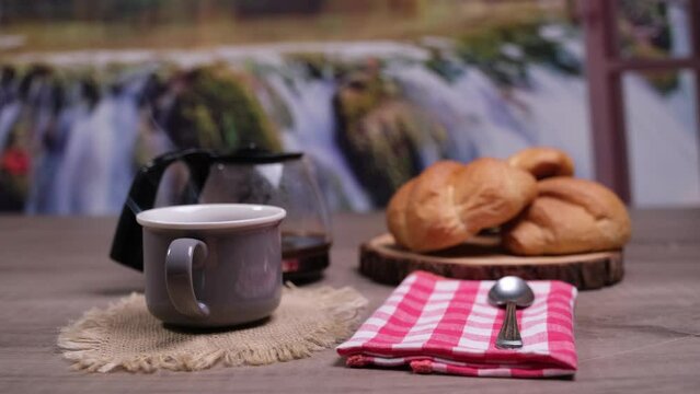 Caff&egrave; caldo fumante nella tazza, colazione con cornetti sul tagliere e caff&egrave;