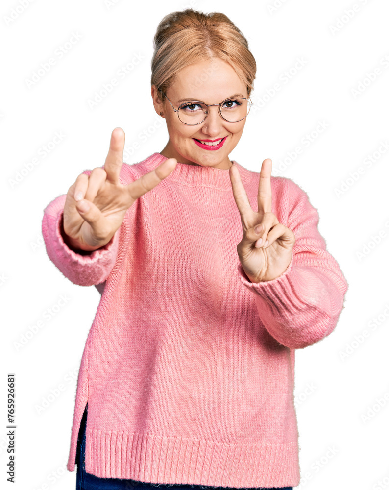 Canvas Prints Young blonde woman wearing casual clothes and glasses smiling looking to the camera showing fingers doing victory sign. number two.