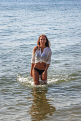 Beautiful girl comes out of the sea with waves