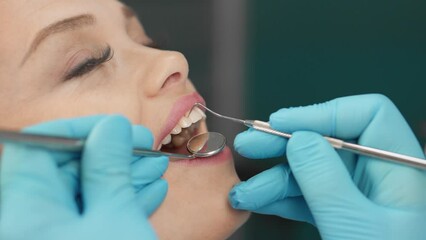 With attentiveness and calmness, the woman sits in the dental chair, where the doctor treats her teeth with great care, ensuring a painless and effective treatment process.