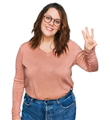 Young plus size woman wearing casual clothes and glasses showing and pointing up with fingers number three while smiling confident and happy.