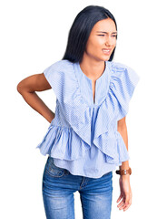 Young beautiful latin girl wearing casual clothes suffering of backache, touching back with hand, muscular pain