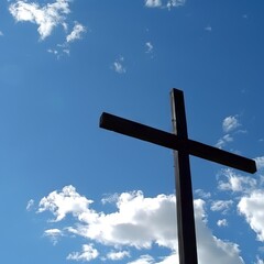 Silhouette of a wooden cross with shining light against a blue sky with clouds.
Concept: Suitable for use in religious publications, spirituality and faith, Christian music album covers, faith in God 