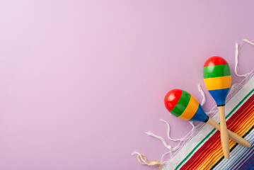 Cinco de Mayo vibe. Top view of symbolic objects: maracas a colorful serape on a soft purple base, leaving space for text or ad - obrazy, fototapety, plakaty