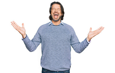 Middle age handsome man wearing casual clothes celebrating mad and crazy for success with arms...