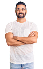 Young hispanic man wearing casual clothes happy face smiling with crossed arms looking at the camera. positive person.