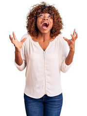 Young african american woman wearing casual clothes crazy and mad shouting and yelling with...