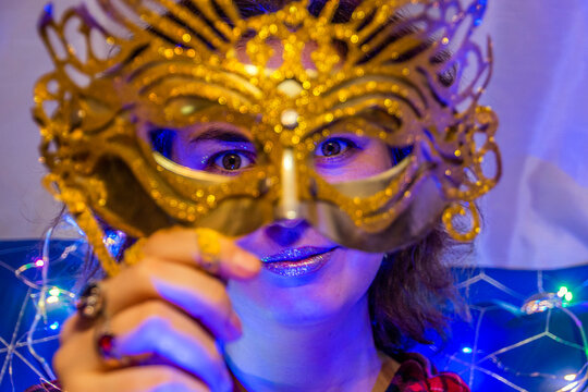 Beautiful girl holding a New Year's mask