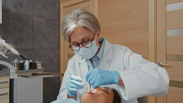 Dentist Examining Woman's Teeth: Camera Zooms from Medium to Close-up