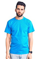 Young handsome man with beard wearing casual t-shirt relaxed with serious expression on face. simple and natural looking at the camera.
