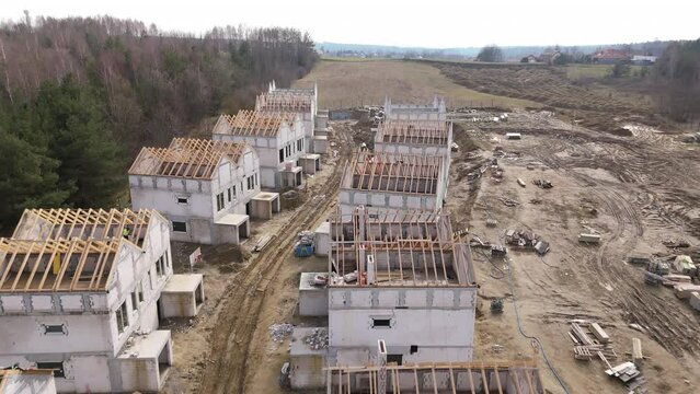 Aerial View of Residential Construction Site with Unfinished Buildings and Building Materials
