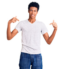 Young african american man wearing casual white t shirt looking confident with smile on face,...