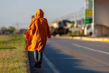 A homeless man walking alone on the motorway. A lonely person.