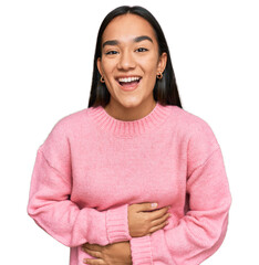 Young asian woman wearing casual winter sweater smiling and laughing hard out loud because funny crazy joke with hands on body.