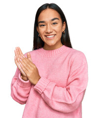 Young asian woman wearing casual winter sweater clapping and applauding happy and joyful, smiling proud hands together