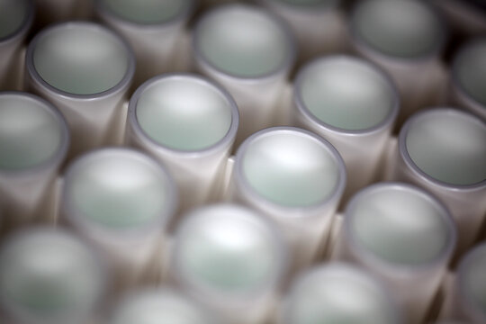 Close-up of a white plastic 96-well plate used for luminescence measurement in biology - shallow depth of field