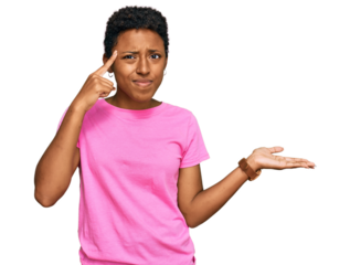 Young african american woman wearing casual clothes confused and annoyed with open palm showing copy space and pointing finger to forehead. think about it.