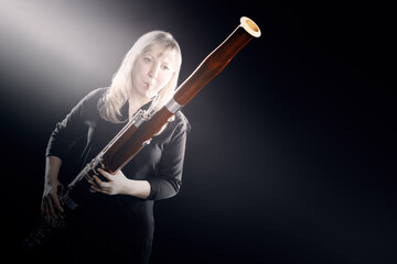 Bassoon woodwind instruments player. Classical musician woman playing orchestral bass - 765962056