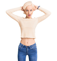 Young blonde woman wearing casual clothes crazy and scared with hands on head, afraid and surprised...