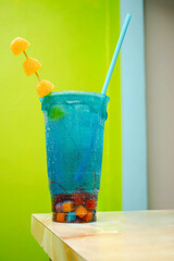 Imagen vertical de una bebida hecha de vodka llamada azulito con gomitas y dulces 