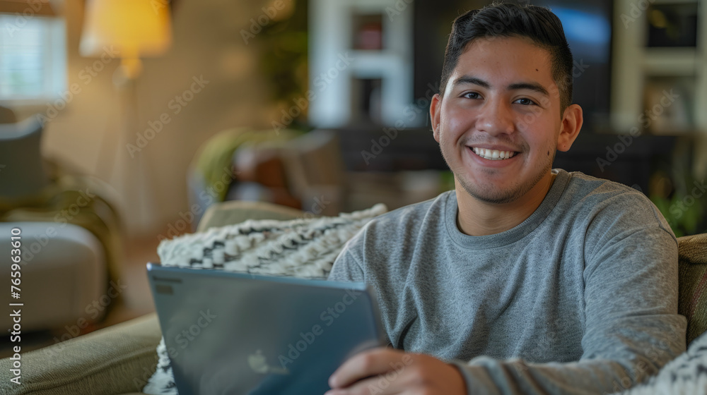 Wall mural Stylish, modern man smiling at camera and using a notebook.