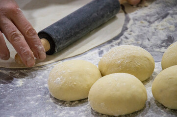 Preparation of the dough. Rolled out pizza and rolling pin on flour, top view, crop