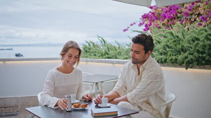 Loving pair resting cafe terrace closeup. Happy woman feeding boyfriend dessert