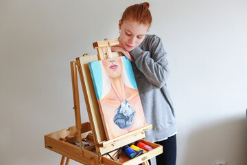  the girl had just finished a painting and was leaning on the easel