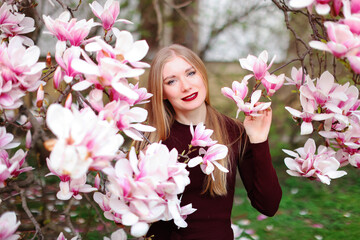 beautiful young girl posing in blooming magnolia