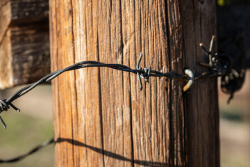 rusty barbed wire on weathered fence post