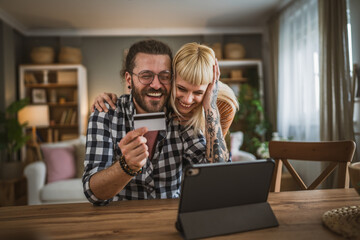 adult happy couple man and woman shopping online hold credit card