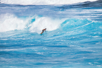 Unrecognizable surfer in the blue hawaii surf.
