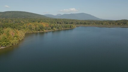 Obraz premium Hazy lake with mountains in the distance on a beautiful sunny morning