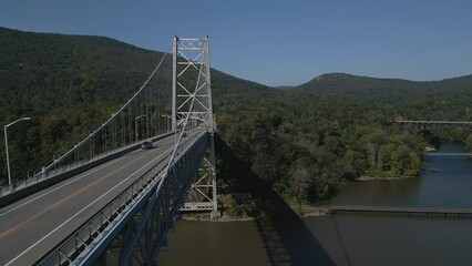 Suspension bridge against mountain backdrop on sunny summer morning