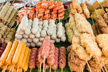 Cooked street food including sausages, prawns,fish balls, pork balls on a stall in Chinatown, Bangkok, Thailand