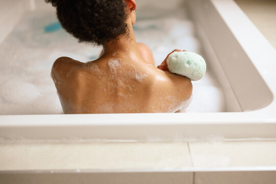 Bathing with a sponge in a jacuzzi, a woman reveals barechest