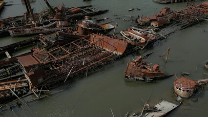 Fototapeta na wymiar Remains of ship vessels disintegrating in harbor