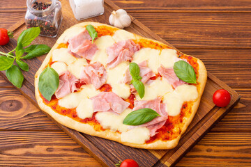 Traditional italian pizza with ham mozzarella and  basil