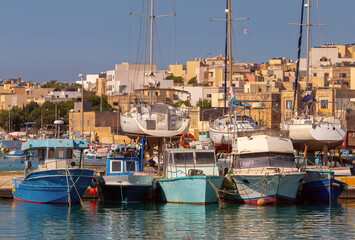 Multi-colored fishing boats luzzi with eyes in the harbor of the village Marsaxlokk on the island Malta. - 766002225
