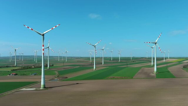 Aerial view of wind turbines and agriculture fields. Windmills turbines generating electricity, green energy, 4k