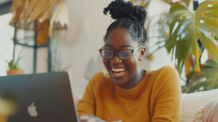 Happy black woman working remotely from home smiling on virtual meeting video call socialising with colleagues. Positive and flexible remote work culture. Candid afro american female digital on laptop