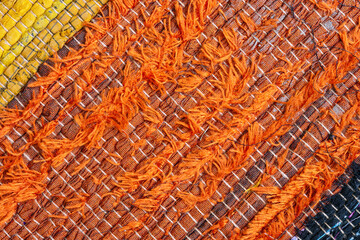 Detail of orange thread patterns on a rag rug