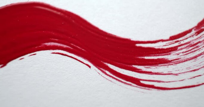 Various clips of an artist's paintbrush with brush strokes painting vibrant red and blue paint lines across the canvas.