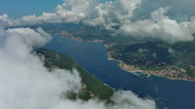 Aerial view on clouds over Kotor Bay, Montenegro. Flying in clouds over sea bay, 4k
