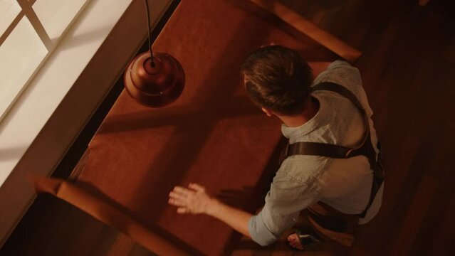Shoemaker rolls out and inspects leather material on the table in the workshop top view.