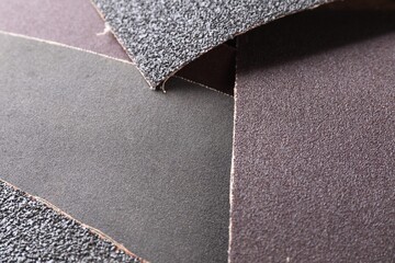 Many sheets of sandpaper as background, closeup