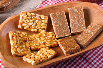 Pé de moleque and peanut candy in a wooden bowl. Traditional sweets from Brazilian country festivals. Brazilian Portuguese