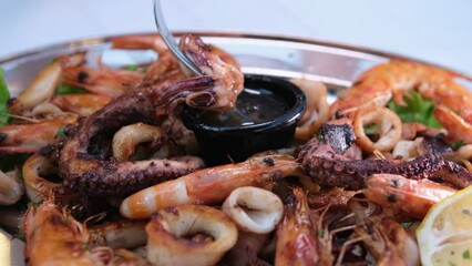 girl happily eats seafood in restaurant. Octopus piece delicious soy sauce unagi. Delicious food in Albania shrimp octopus seafood. Summer restaurant on the terrace. Close-up face white skin pleasure - Powered by Adobe