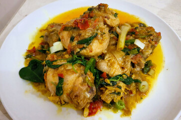 Ayam woku is a traditional dish from the Minahasa or Manado region of Indonesia, made of a chicken cooked mix of herbs and spices, ingredients are lemongrass, turmeric, kaffir lime leaves,